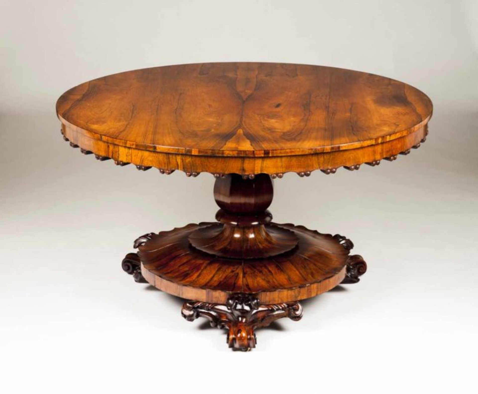 A Victorian breakfast table Rosewood Tilt-top, carved feet with castors England, 19th century