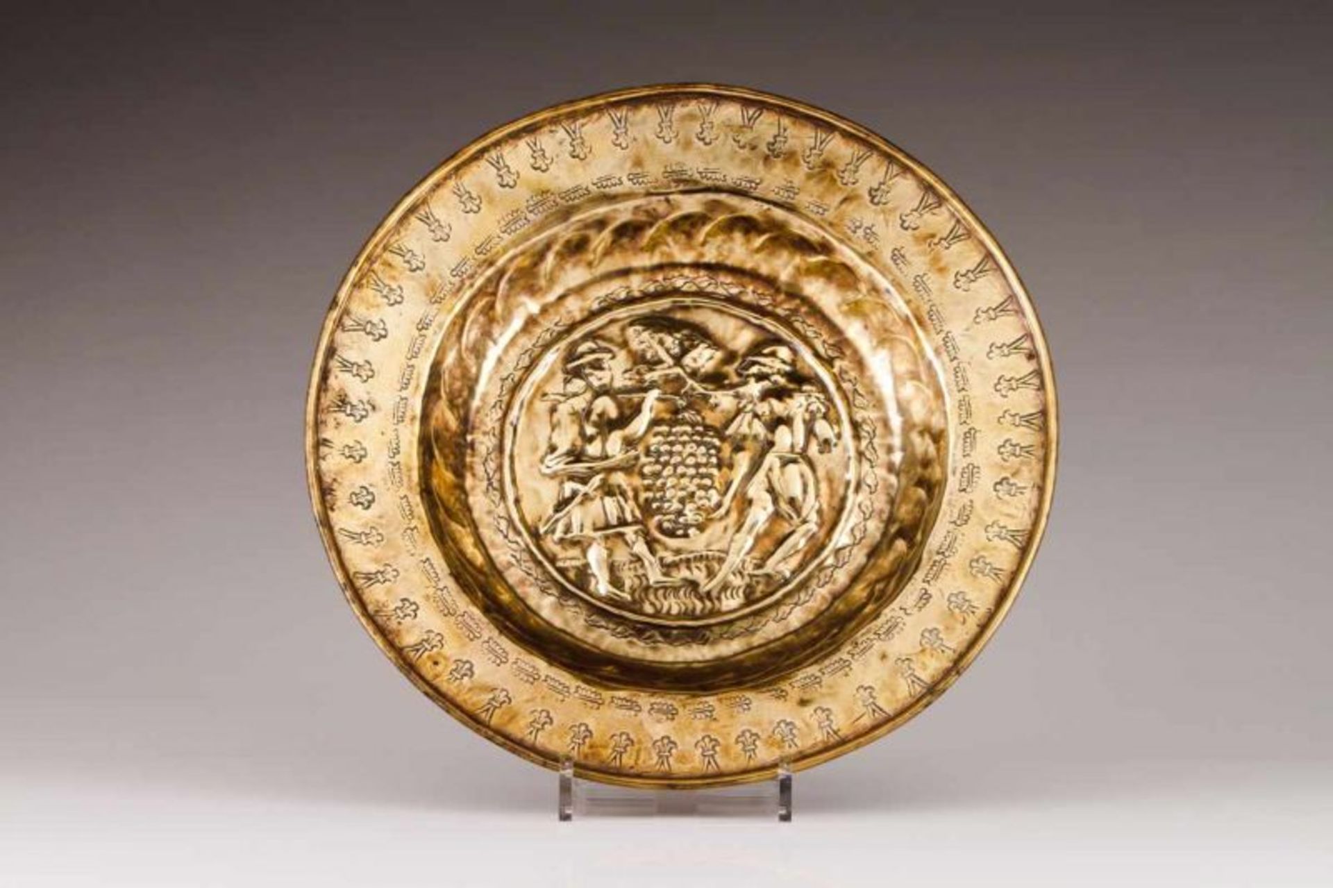 A Nuremberg alms dish Brass Decorated in relief depicting "Joshua and Caleb carrying grapes"