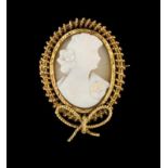 A brooch Conch cameo depicting a feminine profile, filigree gold frame decorated with ribbon