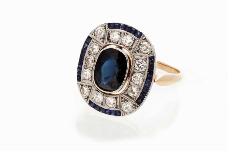 An Art Deco ring Set in gold and platinum with calibrated sapphires, one oval cut sapphire and