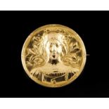 An Art Nouveau brooch Gold Decoration in relief depicting a feminine figure on a floral ground,