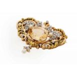 A Retro brooch Set in gold and platinum Designed as a baroque cartouche with volutes and floral