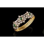 A bangle 18kt gold and silver Centre set with three cabochon emeralds, single cut diamonds and