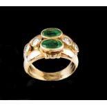 A ring Set in gold with two oval cut emeralds and four brilliant cut diamonds (ca. 0,60ct)