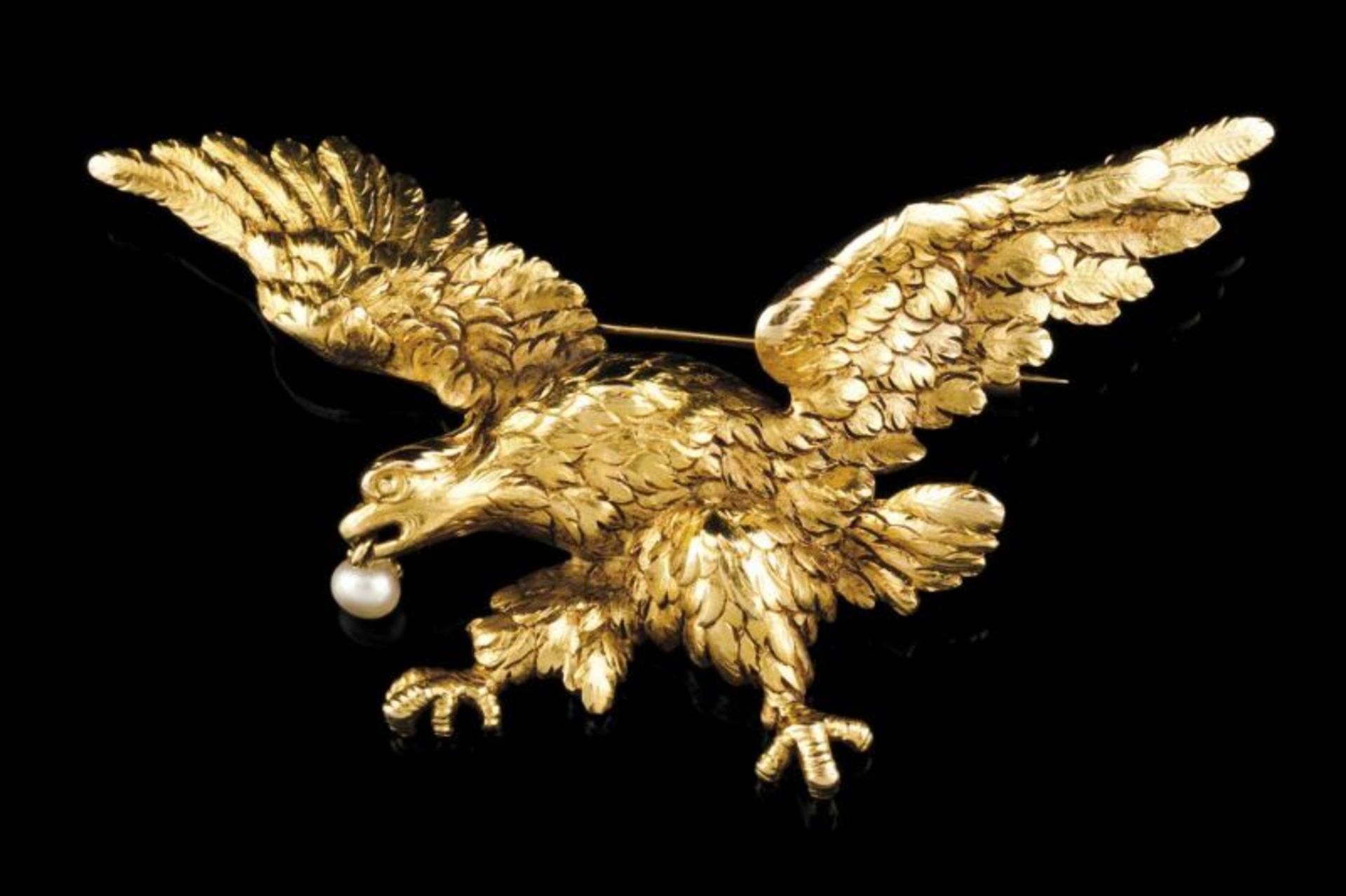 A brooch Chiselled gold representing eagle flying holding a pearl Chiselled back Original fitted