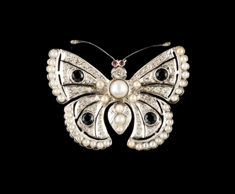 A "butterfly" brooch Set in platinum with half-pearls, four sapphires, two rubies and single cut