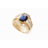 A ring 18kt gold set with one oval cut sapphire (10,2x8,0x5,1 mm), 38 trapeze cut diamonds and 12