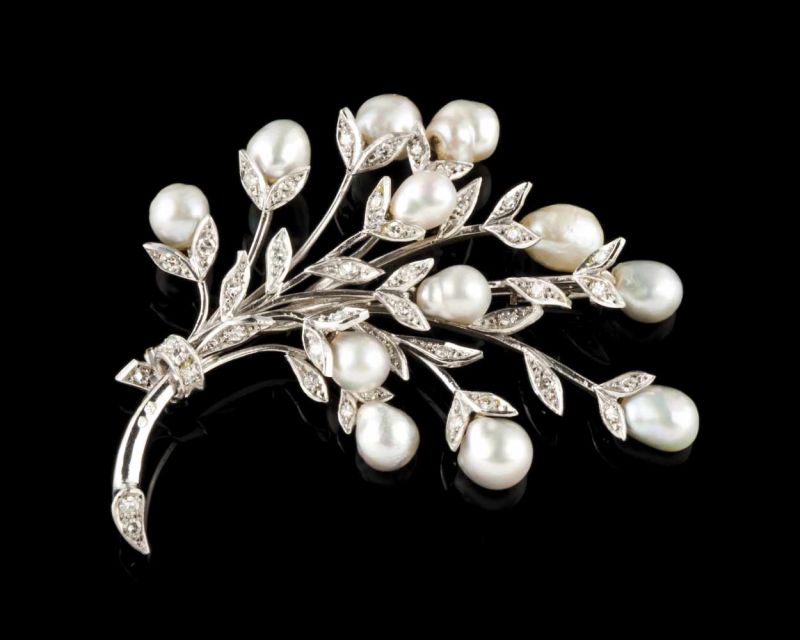 A brooch 9kt white gold set with single cut diamonds and cultured pearls, three articulated