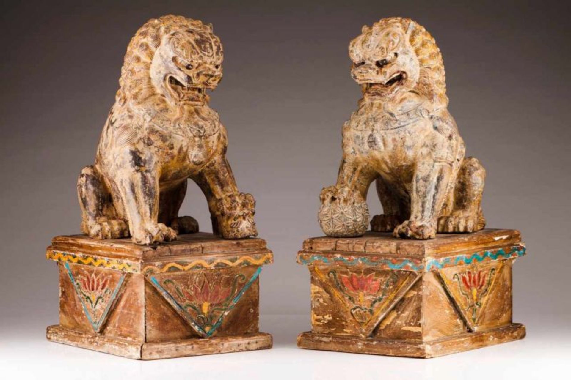 A couple of Buddhist lions Cast iron Represented seated on wood bases with traces of polychromy With