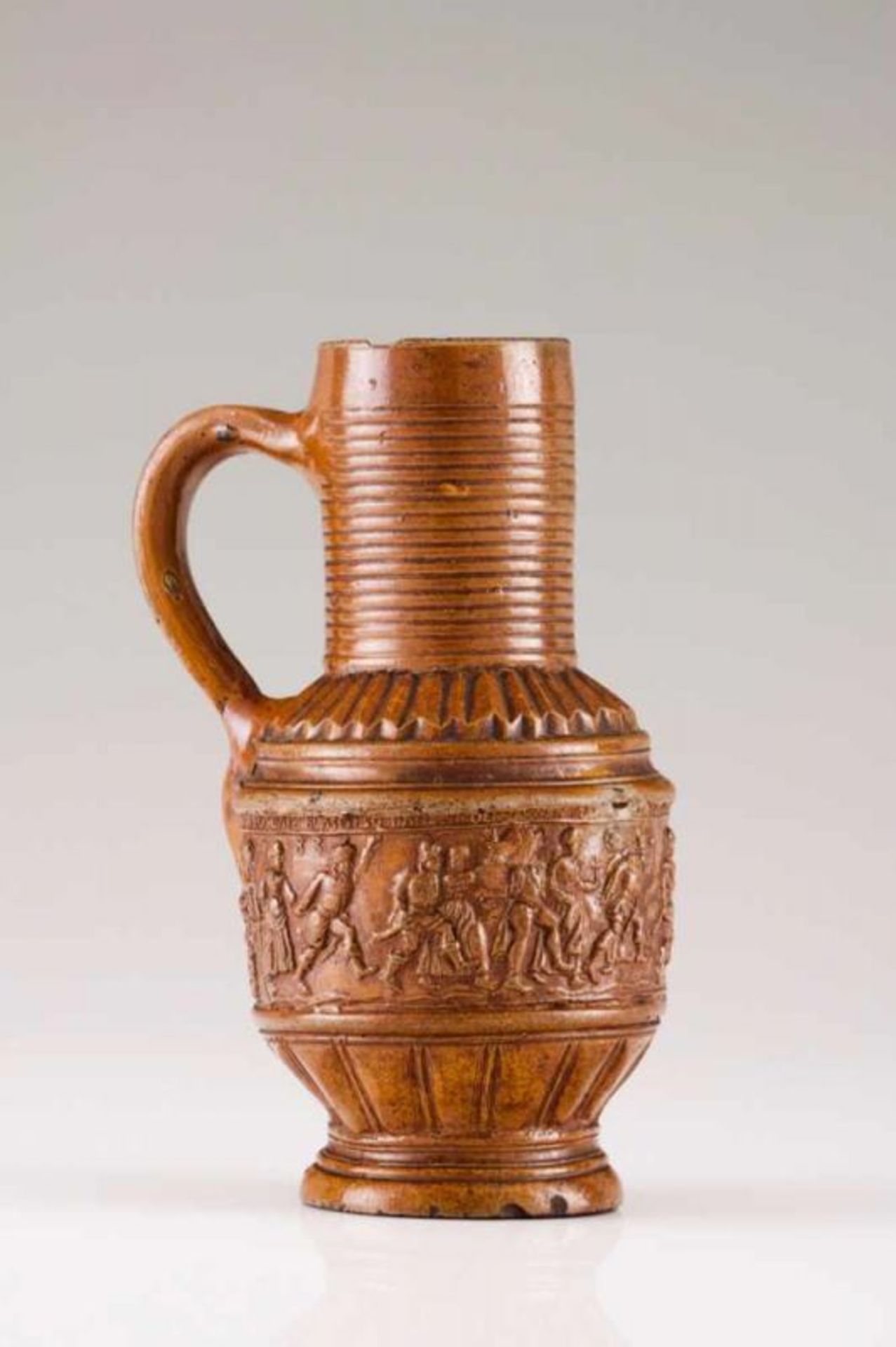 A beer jug German faience Monochron in brown shades Decorated in relief with tavern scenes Dated
