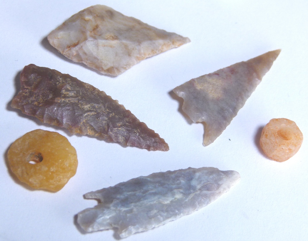 Four British flint arrowheads and two pressed amber beads