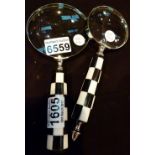 Two black and white handled magnifying glasses