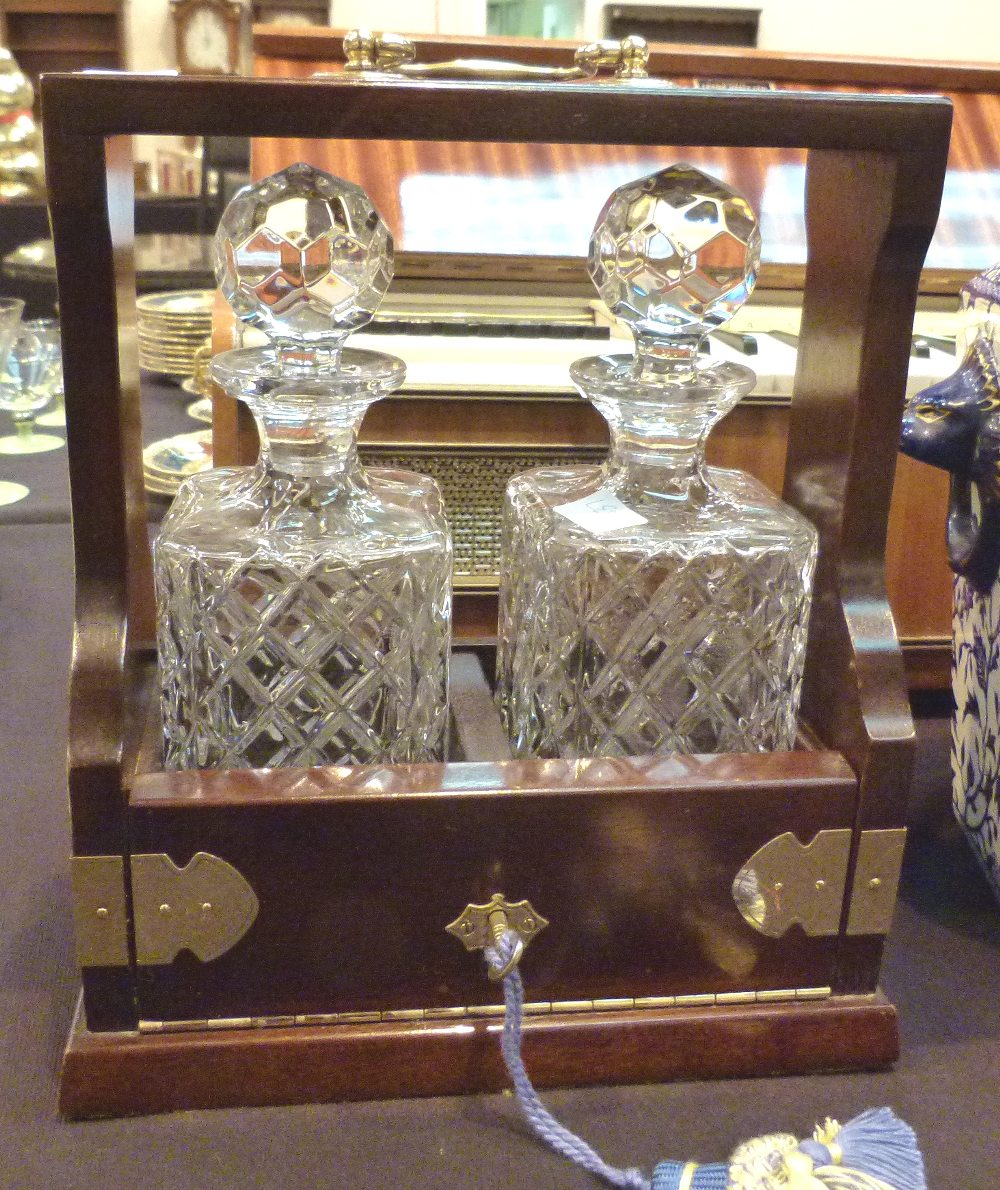 Brass bound mahogany tantalus with a pair of matching decanters,