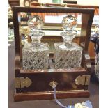 Brass bound mahogany tantalus with a pair of matching decanters,