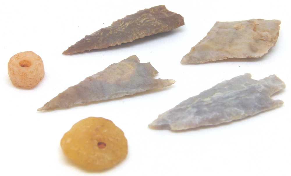 Four British flint arrowheads and two pressed amber beads