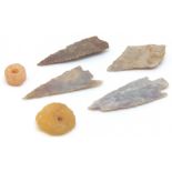 Four British flint arrowheads and two pressed amber beads