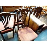 Oval wood dropleaf dining table with rope design edging and five matching chairs.