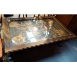 Rectangular wooden coffee table with embossed copper decorative panel under glass top