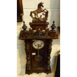 Walnut cased Vienna chiming wall clock with carved columns and topped with a horse