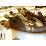 Four carved Indian knives in sheaths and a fish fork