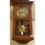 Oak cased German chiming wall clock with pendulum and key