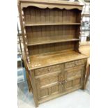 Dark oak heavily carved priory style side board with back plate rack / cupboard