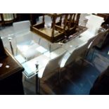 Large modern glass and stainless steel dining table with eight matcing white leather chairs