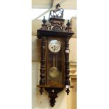 Walnut cased Vienna chiming wall clock with carved columns and topped with a horse