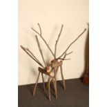 A pair of quirky wooden reindeer figures made in an organic fashion out of natural log pieces.