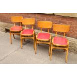 A set of 4 Mid Century beech and beech plywood dining chairs coming with red vinly seat pad and