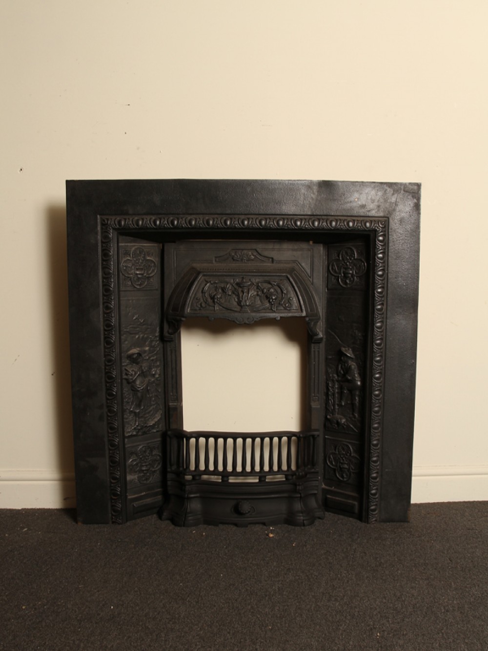 Victorian cast iron insert with decorative panels of a male and female figures with decorative