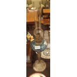 Arts and Crafts style oil lamp with a blue glass shade,