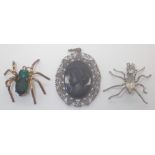 Two metal stone set spider brooches and a black cameo brooch