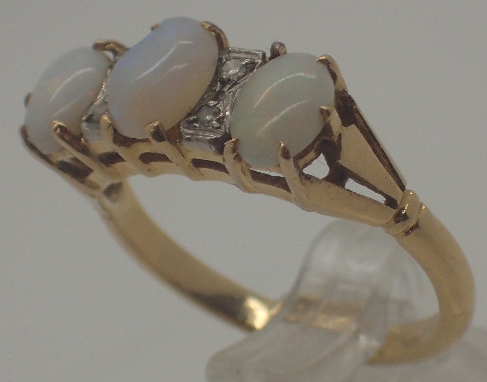 18 ct gold three stone opal and small diamond ring, size N, 3.