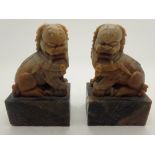 Pair of carved alabaster foo dogs on stands