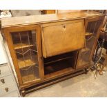 Oak bureau with fitted interior and side by side lead glazed display shelves,