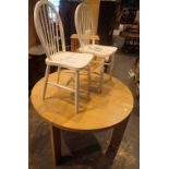 Circular oak dining table and two stick back chairs