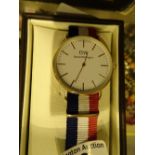 New and boxed yellow metal Daniel Wellington wristwatch on a fabric strap