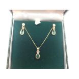 Boxed 9ct gold emerald and diamond pendant and earring set complete with 9ct gold chain and