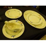 Three Clarice Cliff plates and a gravy boat in large floral pattern