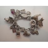 Silver charm bracelet with twenty four large charms,