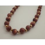 Single strand gold fleck hardstone necklace with 9ct gold clasp,