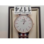 New and boxed yellow metal Daniel Wellington wristwatch on a fabric strap