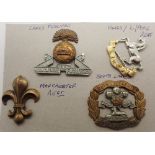 Four WWI cap badges