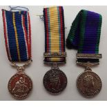 Three miniature military medals with ribbons