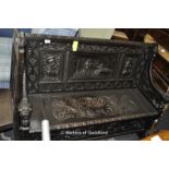 Jacobean style carved oak settle with gold animal detail and an inset panel depicting a Jacobean