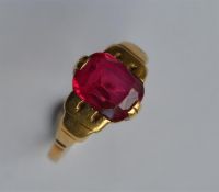 A heavy 9 carat red stone ring in claw mount. Appr
