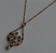 A small gold and pearl drop pendant on fine link c