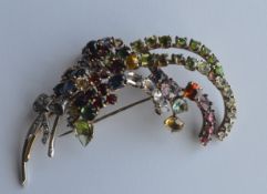 A large gold and multi gem set brooch in the form