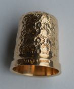 A 9 carat engraved thimble with floral decoration.